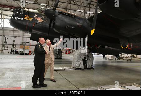 Re Carlo III parla con Seb Davey del Battle of Britain Memorial Flight durante una visita al Battle of Britain Memorial Flight (BBMF) a Coningsby, Lincolnshire, per commemorare il 80° anniversario dell'operazione Chastise, mentre visiti il Lincolnshire. Data immagine: Lunedì 24 luglio 2023. Foto Stock