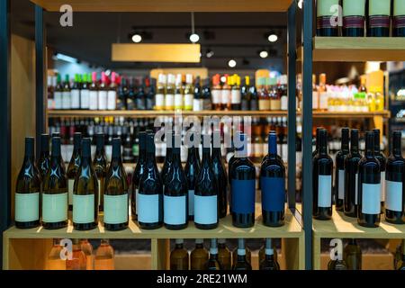 Bottiglie di vino in fila sullo scaffale. Foto Stock