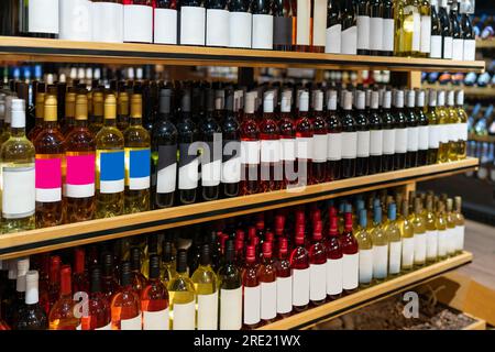 Fondo di bottiglie di vino in primo piano sugli scaffali. Foto Stock