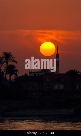 Sole che si trova dietro il minareto sul Nilo Foto Stock