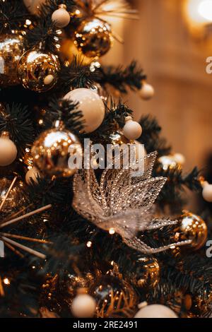 Albero di Natale decorato con palle natalizie dorate e decorazioni in cristallo con fiocchi di neve. Carta da parati natalizia con magiche luci bokeh. Capodanno Foto Stock