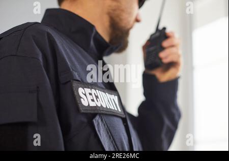 Ritratto di un uomo della guardia di sicurezza in uniforme e che parla con il walkie talkie. Foto Stock