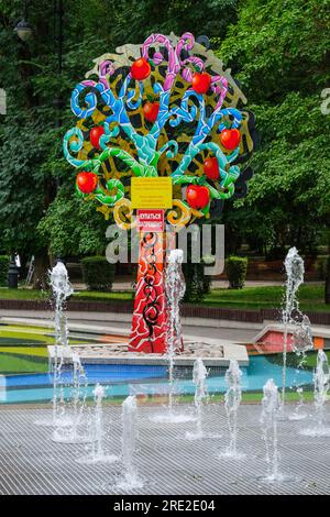 Kazakistan, Almaty. Alberi decorativi colorati vicino alla fontana, Central Park for Culture and Recreation. Foto Stock