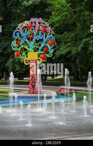 Kazakistan, Almaty. Alberi decorativi colorati vicino alla fontana, Central Park for Culture and Recreation. Foto Stock