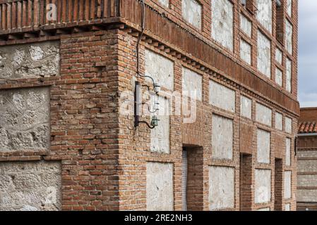 Un vecchio edificio con pareti in mattoni di argilla dall'aspetto antico e collegamenti elettrici in porcellana e vetro Foto Stock