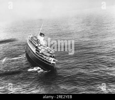 Nantucket, Massachusetts: 26 luglio 1956 il transatlantico italiano "SS Andrea Doria", che si era scontrato con il transatlantico svedese "MS Stockholm" al largo della costa di Nantucket. Notare le imbarcazioni di salvataggio sul lato di porto che non hanno potuto essere abbassate e utilizzate a causa dell'elenco a tribordo. La nave è affondata poco dopo che è stata scattata questa foto. Foto Stock