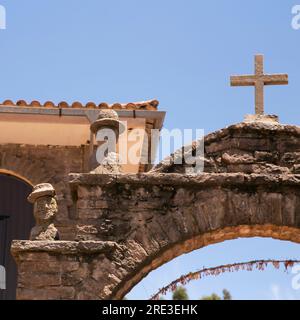 Teste di pietra scolpite negli archi sull'isola di Taquile sul lago Titicaca in Perù. Foto Stock