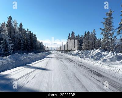 Strada innevata in inverno nel nord della Svezia Foto Stock