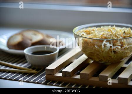 Spaghetti di riso coreani con carne e spezie. Tagliatelle con salsa e pane. Noodle Stick. Foto Stock