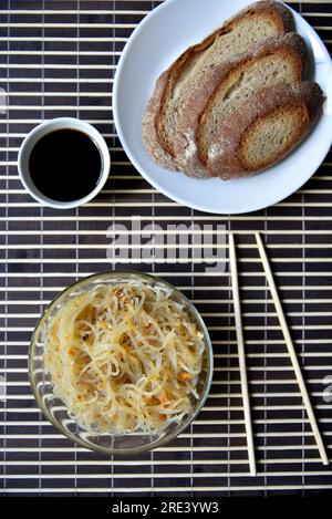 Spaghetti di riso coreani con carne e spezie. Tagliatelle con salsa e pane. Noodle Stick. Foto Stock