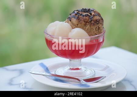 Gelato al caffè con cioccolato sopra posto in un bicchiere con gelatina e frutta. Foto Stock