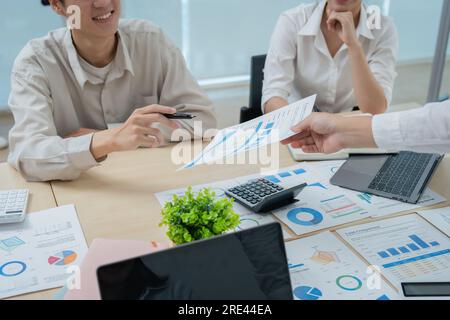 Riunione di consulenti aziendali asiatici per analizzare e discutere la situazione sul rapporto finanziario nella sala riunioni.Consulente investimenti Foto Stock