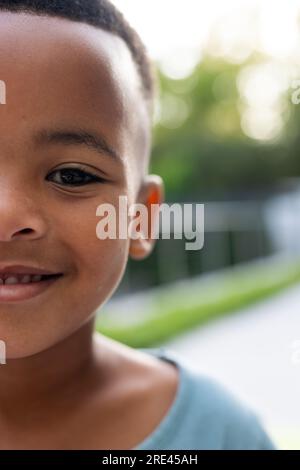 Metà ritratto di un ragazzo afro-americano felice sulla terrazza soleggiata di casa Foto Stock