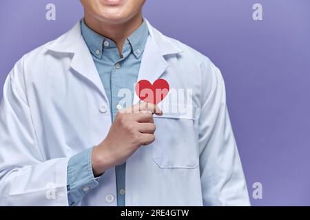 medico con forma di cuore rossa su sfondo viola Foto Stock