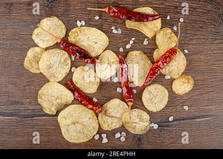 Vista dall'alto di patatine fritte, sale grossolano e cialde di pepe caldo su uno sfondo di legno. Ottimo per festival della birra, pub, pubblicità di ristoranti. Fotografia di Foto Stock