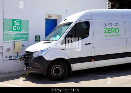 Pulmino Polygreen "Just Go Zero" al punto di ricarica per veicoli elettrici, isola di Tilos, vicino a Rodi, Dodecaneso, Grecia Foto Stock