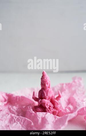 La candela con la dea Lakshmi è rosa. Femminilità e fertilità. Meditazione e buddhismo Foto Stock