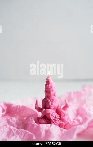 La candela con la dea Lakshmi è rosa. Femminilità e fertilità. Meditazione e buddhismo Foto Stock