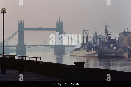 Le navi della Royal Navy HMS Active ormeggiarono a fianco della HMS Belfast sul Tamigi presso il Tower Bridge. Londra. Inghilterra. 21 maggio 1985 Foto Stock