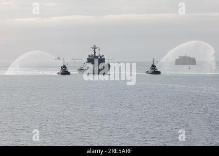 I rimorchiatori forniscono un cannone d'acqua alla nave da ricognizione della Royal Navy HMS ENTERPRISE (H88) mentre arriva alla base navale per la disattivazione Foto Stock