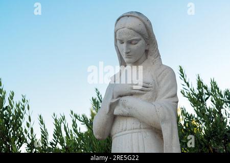 Crikvenica, Croazia - 18 luglio 2023: Statua della Vergine Maria di fronte alla Chiesa dell'assunzione della Beata Vergine Maria Foto Stock