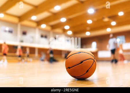 Pallacanestro sul campo di legno. Partita di pallacanestro su sfondo sfocato. Sfondo campo da pallacanestro. Pallacanestro sportivo classico Foto Stock