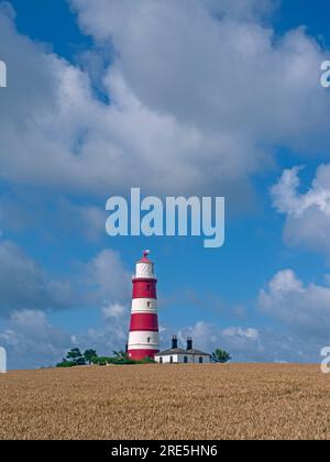 Un campo di maturazione del grano e Light House Happisburgh Norfolk Regno Unito Foto Stock