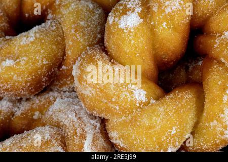 Un lotto di ciambelle appena fatte con vista ravvicinata dello zucchero Foto Stock