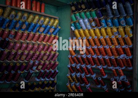 Set di vari fili colorati posizionati sull'organiser su entrambi i lati della parete Foto Stock