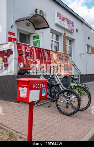 Negozio polacco del villaggio, con cassetta postale e biciclette dei clienti all'esterno, comunità rurale, paesaggio di campagna polacco, stile di vita del villaggio. Rosso Foto Stock