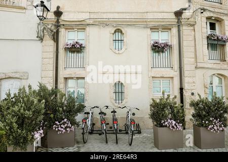 Biciclette di fronte a una bella facciata di una vecchia casa ornata con fiori a Ortigia, Siracusa, Sicilia, Italia Foto Stock