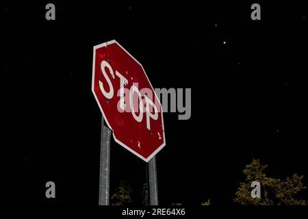 Fotografia ad alta definizione di un segnale di stop scattato da qualche parte nel deserto dell'Arizona di notte. Foto Stock