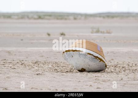 Dugway, Stati Uniti d'America. 18 luglio 2023. Una capsula di pratica poggia sul deserto mentre le squadre di recupero della NASA partecipano ad un recupero simulato della capsula di ritorno del campione della missione OSIRIS-Rex presso il Department of Defense Utah test and Training Range, 18 luglio 2023. Il campione reale è stato raccolto dall'asteroide Bennu dalla navicella spaziale OSIRIS-Rex e sarà inviato sulla Terra il 24 settembre 2023, atterrando sotto paracadute. Crediti: Keegan Barber/NASA/Alamy Live News Foto Stock