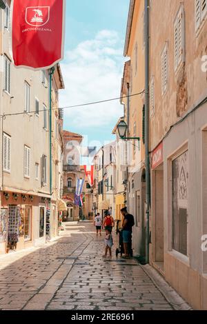 Rab Croazia - 4 luglio 2023: Strada principale della città vecchia di Rab con persone che camminano. Foto Stock