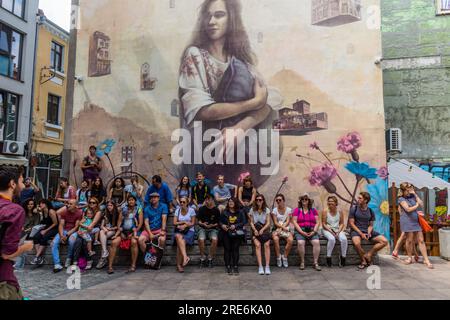 PLOVDIV, BULGARIA - 29 LUGLIO 2019: Partecipanti a un tour a piedi gratuito sotto un graffito su un muro nel distretto creativo di Kapana a Plovdiv, Bulgaria Foto Stock
