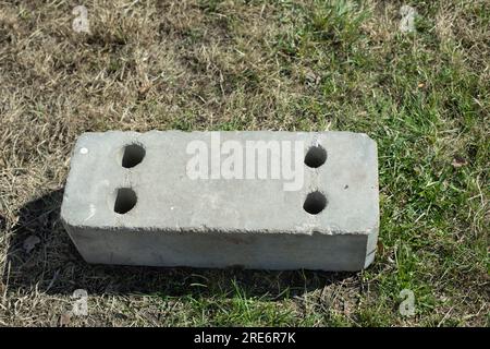 Blocchi di cemento giacciono sull'erba. Detriti di costruzione nel parco. Il blocco di cemento si trova a terra. Rifiuti industriali. Foto Stock