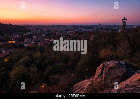 Tramonto visto dalla collina di Danov nella città di Plovdiv, Bulgaria. Una storica torre dell'orologio, costruita nel 1812, è visibile sulla destra Foto Stock