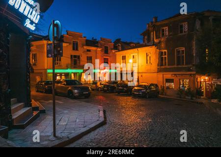 La luminosa segnaletica al neon del ristorante Vivaldi illumina una strada della città vecchia a Plovdiv, Bulgaria Foto Stock