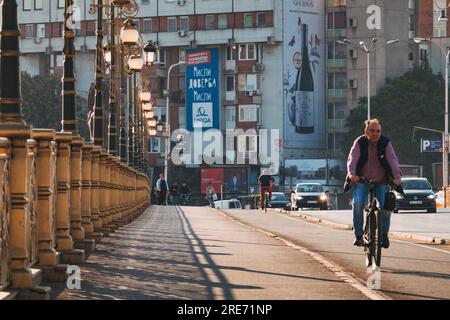 Un uomo cavalca la sua bicicletta in una pista ciclabile sul ponte Goce Delchev nella città di Skopje, in Macedonia del Nord Foto Stock