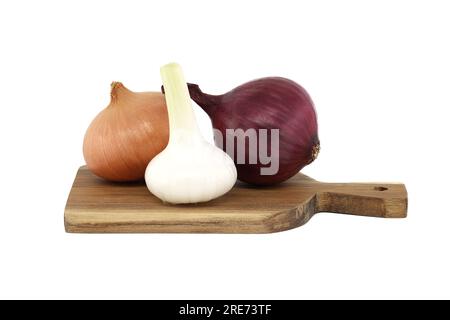 Bulbo d'aglio fresco tra cipolle rosse e gialle su tagliere di legno isolato su sfondo bianco. Spezie, erbe aromatiche e tema aromatizzante natura morta Foto Stock