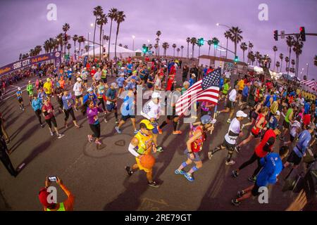 Huntington Beach, California, USA. 5 febbraio 2017. I concorrenti della maratona multirazziale prima di una maratona lasciano la linea di partenza la mattina presto a Huntington Beach, CALIFORNIA, conosciuta colloquialmente come ''Surf City''. Nota bandiera americana portata dal corridore. (Immagine di credito: © Spencer Grant/ZUMA Press Wire) SOLO USO EDITORIALE! Non per USO commerciale! Foto Stock