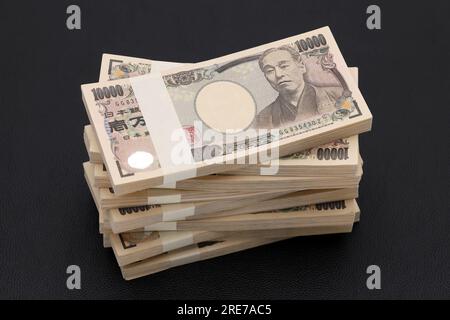 Pila di yen giapponesi. pacchetto di banconote da 10.000 yen. Le banconote sono scritte come "10.000 yen" in giapponese. Foto Stock