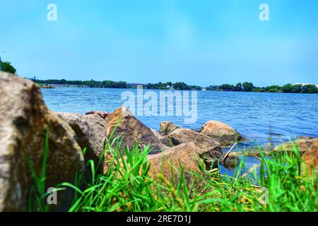 Immergetevi nel fascino tranquillo di un pittoresco fiume in Cina, le sue acque cristalline che riflettono il vasto cielo blu sotto il caldo emb Foto Stock