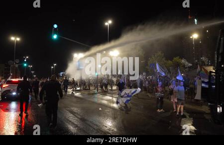 La polizia usa un cannone ad acqua per disperdere i manifestanti anti-governativi che bloccano una strada nei pressi della corte suprema durante una protesta contro il governo di destra di Israele e l'approvazione della legge giudiziaria in parlamento oggi il 24 luglio 2023 a Gerusalemme, Israele Foto Stock