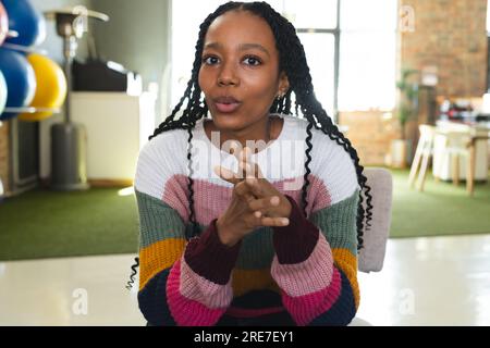 Donna d'affari afroamericana che effettua videochiamate in ufficio Foto Stock