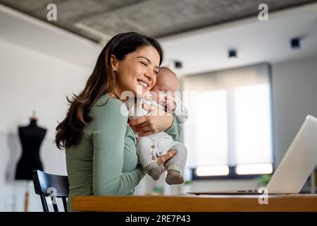 Madre con bambino che videochiama online, parla con i parenti, comunica con gli amici Foto Stock