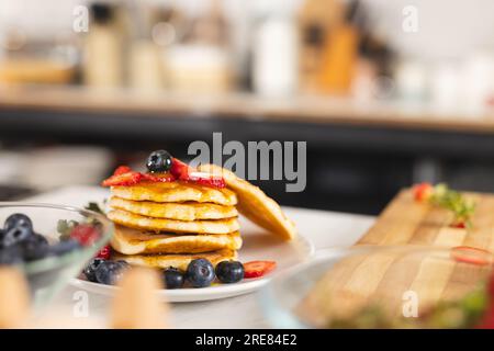 Primo piano di pancake con frutta sul ripiano in cucina a casa Foto Stock