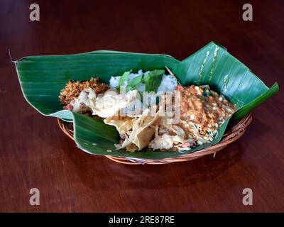 Pecel Pincuk, un cibo tradizionale giavanese, servito su foglie di banana, uno dei pacchetti alimentari ecologici. Foto Stock