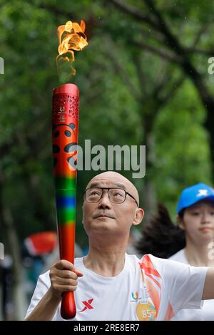 Chengdu, provincia cinese del Sichuan. 26 luglio 2023. Il portatore della torcia Xu Liaoyuan corre con la torcia durante la staffetta della 31a FISU Summer World University Gamesin Chengdu, provincia del Sichuan nel sud-ovest della Cina, 26 luglio 2023. Crediti: Shen Bohan/Xinhua/Alamy Live News Foto Stock