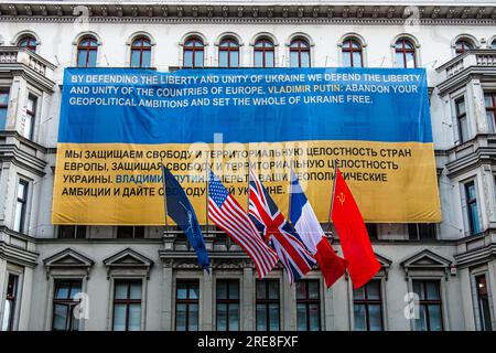 Bandiere alleate (americane, francesi, britanniche, sovietiche) presso il museo di Checkpoint Charlie, Friederichstrasse, Berlino. Facciata con striscione blu e giallo sulla facciata dell'edificio Foto Stock